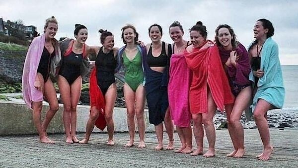 Emer Harrington, in the pink towel fourth from right, finds it ‘healing and energising’ to swim at sunrise every morning.