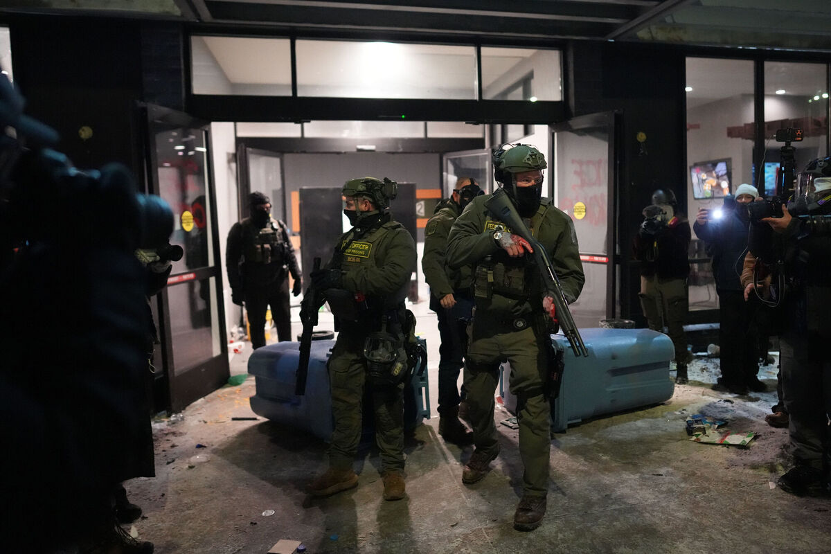 Federal agents stand guard outside a hotel during a noise demonstration protest in response to federal immigration enforcement operations in the city on Sunday, January 25, 2026, in Minneapolis. Picture: Adam Gray/AP