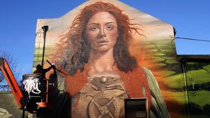 <p>Street artist Mister Copy working on a St Brigid mural in Kildare in 2024. Picture: Brian Lawless/PA</p>
