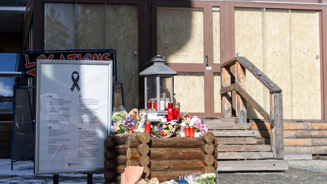 Flower tributes have been left at the entrance to the Le Constellation bar when the fire took place during new year celebrations (Cyril Zingaro/Keystone/AP)