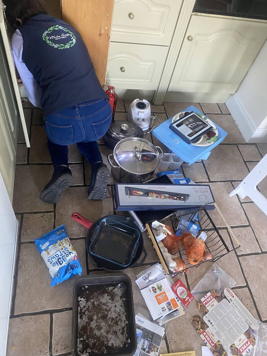Anne Marie sorts the cupboard where Jess keeps her pots and pans.
