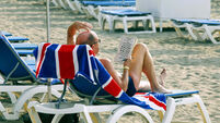 Early morning tourist trying to solve a sudoku, Playa de Las Vistas Beach, Los Cristianos, Tenerife, Canary Islands, Spain