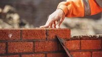 Bricklayer laying another brick in the wall on construction site for sturdy wall