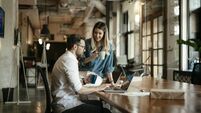 Businessman and businesswoman drinking coffee in the office.