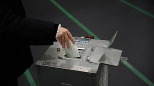 A voter fills in a ballot in the lower house election (Louise Delmotte/AP)