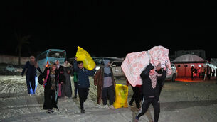 Palestinians carry the belongings of relatives arriving in Gaza from Egypt (Abdel Kareem Hana/AP)