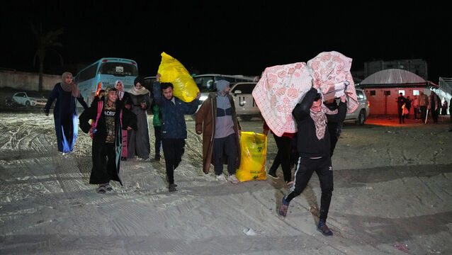 <p>Palestinians carry the belongings of relatives arriving in Gaza from Egypt. Picture: Abdel Kareem Hana/AP</p>
