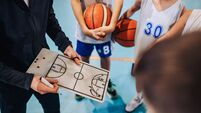 Cropped image of basketball coach working on game plan with junior team