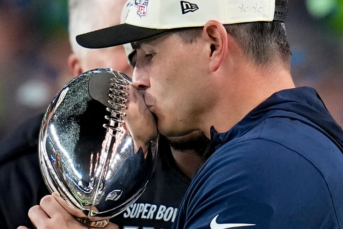 Seattle Seahawks head coach Mike MacDonald kisses the Lombardi Trophy between quarterback Sam Darnold and Seattle Seahawks chair Jody Allen after the NFL Super Bowl 60 football game against the New England Patriots, Sunday, Feb. 8, 2026, in Santa Clara, Calif. (AP Photo/Sue Ogrocki)