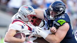 <p>Seattle Seahawks defensive end Rylie Mills, right, sacks New England Patriots quarterback Drake Maye. Pic: AP Photo/Julio Cortez</p>