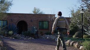 <p>A member of the Pima County sheriffs office remains outside of Nancy Guthrie’s home (Ty O’Neil/AP)</p>