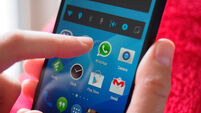 Person holding smartphone with WhatsApp messaging app