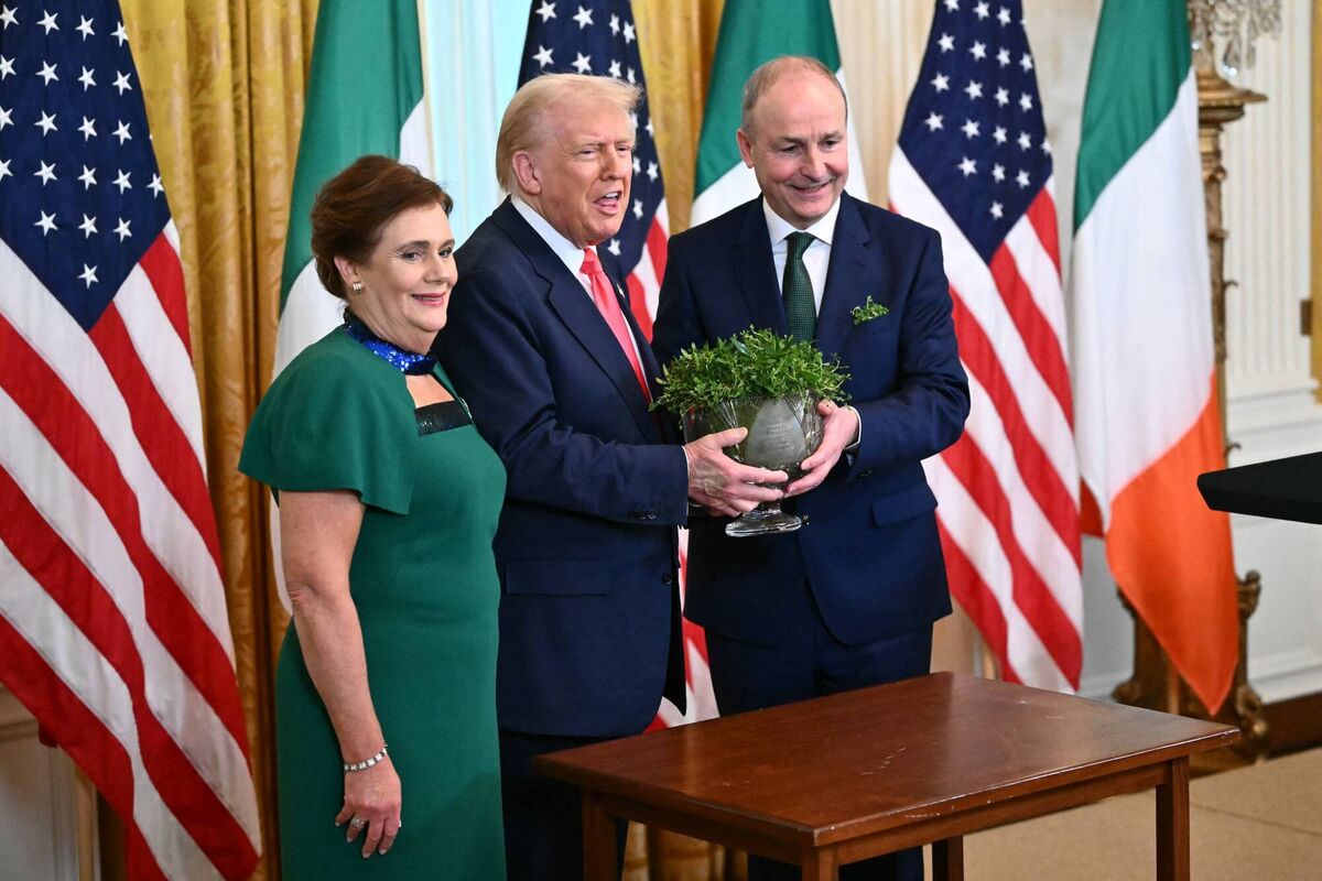 US president Donald Trump (centre), Taoiseach Micheál Martin (right) and his wife Mary O'Shea (left) at last year's St Patrick's Day reception in the White House. That bowl of shamrock now signifies appeasement. Photo: Mandel Ngan/AFP US president Donald Trump (centre), Taoiseach Micheál Martin (right) and his wife Mary O'Shea (left) at last year's St Patrick's Day reception in the White House. That bowl of shamrock now signifies appeasement. Photo: Mandel Ngan/AFP