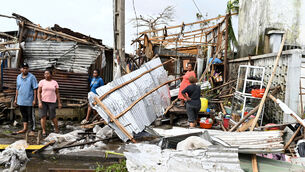 People survey the damage done by Cyclone Gezina in Toamasina, Madagascar (Hery Nirina Rabary/AP)