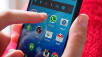 Person holding smartphone with WhatsApp messaging app