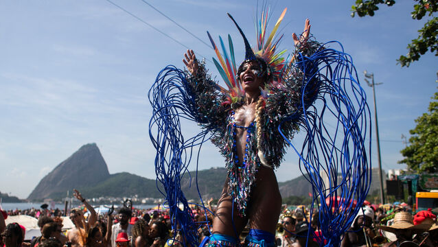 Raquel Poti performs on stilts during the Amigos da Onca Carnival street party in Rio de Janeiro (Bruna Prado/AP)