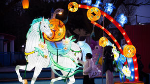 <p>Visitors walk past an illuminated horse lantern display ahead of Lunar New Year celebrations at an amusement park on the outskirts of Beijing Picture: Vincent Thian/AP</p>