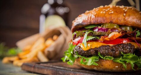 Tasty burgers on wooden table