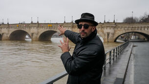 French artist JR gestures towards the Pont Neuf bridge in Paris (Michel Euler/AP)