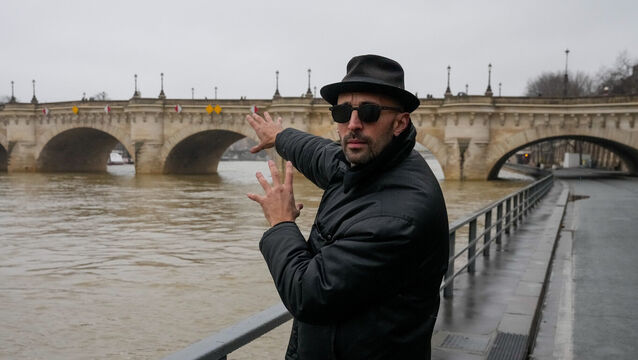 French artist JR gestures towards the Pont Neuf bridge in Paris (Michel Euler/AP)