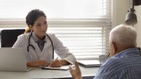 Female doctor therapist listening to patient complaints, filling form