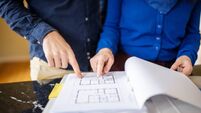 Detail photo of a couple looking at an architectural plan