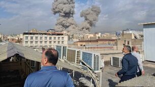 <p>People watch as smoke rises on the skyline after an explosion in Tehran, Iran, Saturday, Feb. 28, 2026.(AP Photo)</p>