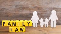 Cubes with letters and family figure on wooden table. Family law concept