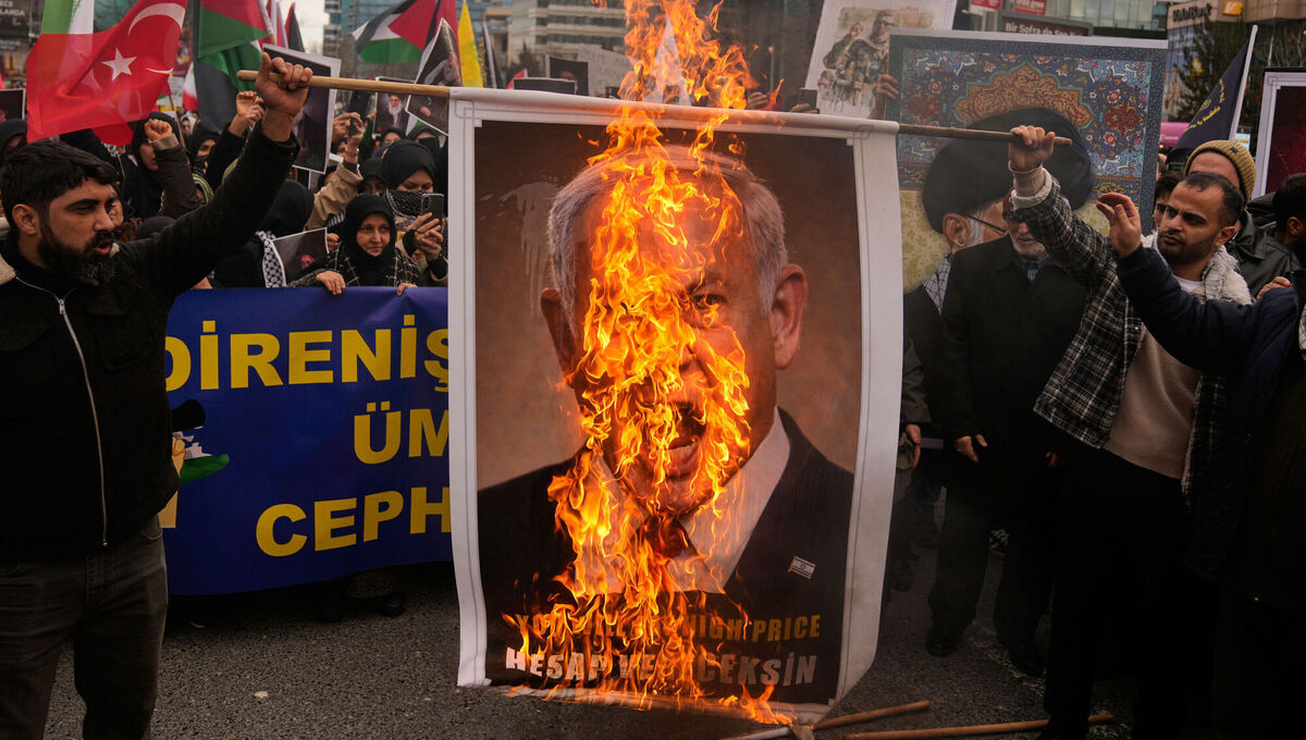 Demonstrators burn a picture of Israeli prime minister Benjamin Netanyahu during a protest outside the Israeli consulate in Istanbul on Sunday. Picture: Khalil Hamra/AP