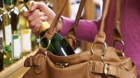 Woman Stealing Bottle Of Wine From Supermarket