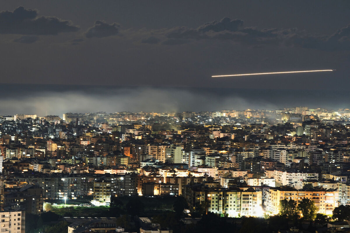 In this photo taken with a slow shutter speed, a Middle East Airlines plane flies over Beirut as smoke rises from Israeli airstrikes on Dahiyeh in Beirut's southern suburbs, early Monday, March 2, 2026. Picture: AP Photo/Hassan Ammar