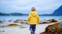 Cute child, running on a Norway white sand beach in the summer