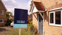 For sale sign in yard of house