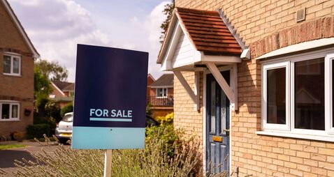 For sale sign in yard of house