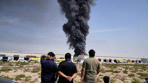 <p>Residents watch as the flames and a black plume of smoke rises from a warehouse at the industrial area of Sharjah City in the United Arab Emirates following reports of Iranian strikes in Dubai, United Arab Emirates, Sunday, March 1, 2026. Picture: AP Photo/Altaf Qadri</p> <p>Residents watch as the flames and a black plume of smoke rises from a warehouse at the industrial area of Sharjah City in the United Arab Emirates following reports of Iranian strikes in Dubai, United Arab Emirates, Sunday, March 1, 2026. Picture: AP Photo/Altaf Qadri</p>