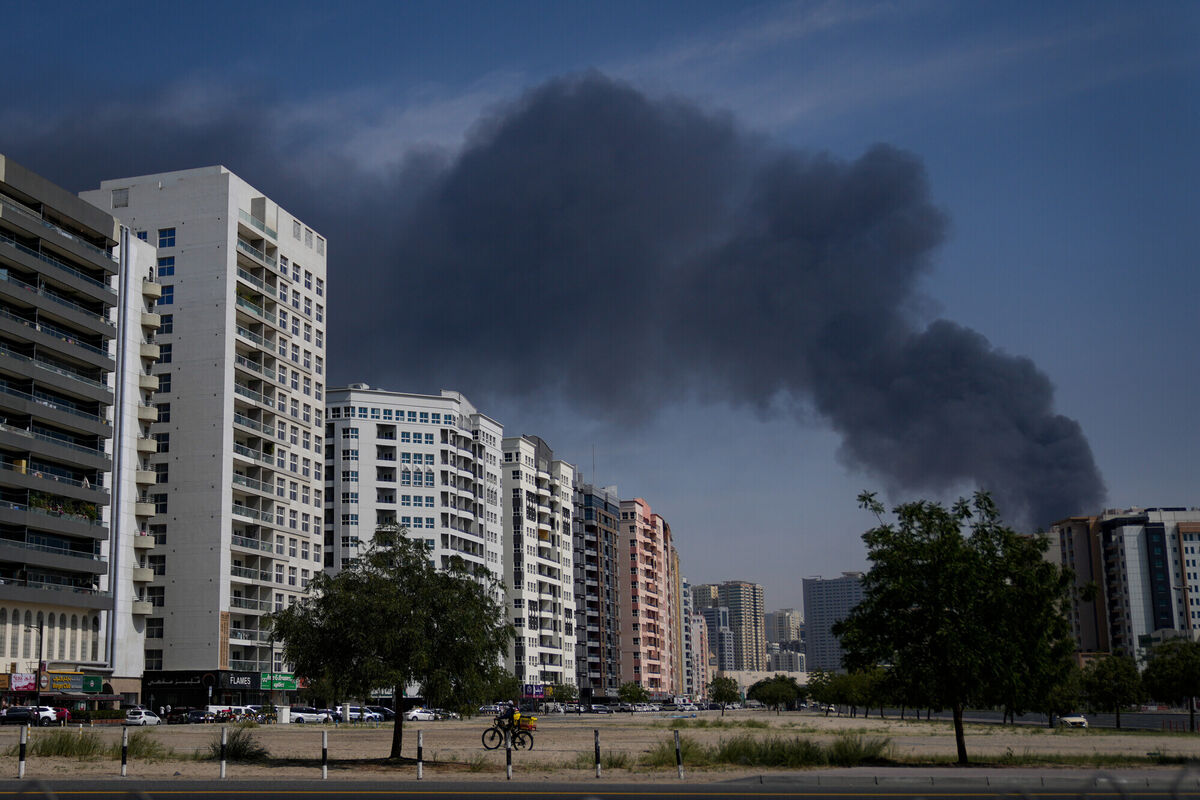 A cyclist rides past as black plume of smoke is seen rising from a warehouse at the industrial area of Sharjah City in the United Arab Emirates following reports of Iranian strikes in Dubai, United Arab Emirates, Sunday, March 1, 2026. Picture: AP Photo/Altaf Qadri A cyclist rides past as black plume of smoke is seen rising from a warehouse at the industrial area of Sharjah City in the United Arab Emirates following reports of Iranian strikes in Dubai, United Arab Emirates, Sunday, March 1, 2026. Picture: AP Photo/Altaf Qadri