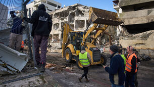 <p>Rescue workers and military personnel work at the scene of a direct hit a day after an Iranian missile struck in Tel Aviv, Israel, Sunday, March 1, 2026. (AP Photo/Oded Balilty)</p>