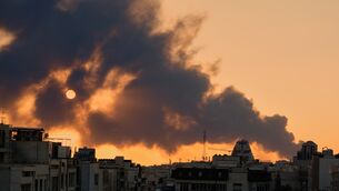 A plume of smoke rises following a military strike in Tehran (Vahid Salemi/AP)