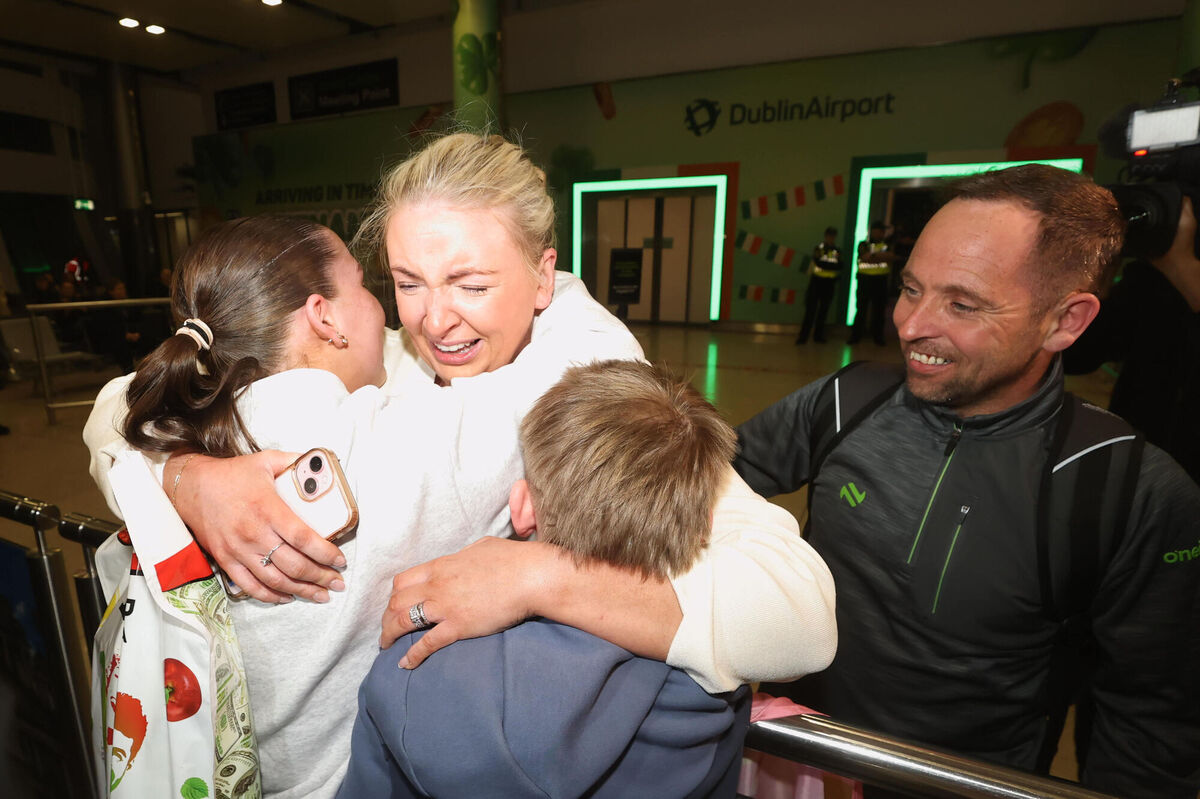 Hugh Mackin looks on as Dymphna Mackin embraces Harry and Eva Rose Mackin after arriving at Dublin Airport on a flight from Dubai in the UAE on Thursday. Picture: Liam McBurney/PA 
