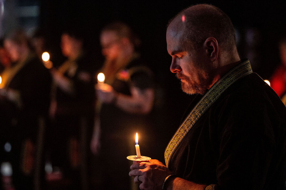 People bow their heads for a moment of silence during a candlelight mat ceremony for former student and instructor Noah Tietjens, who was killed in a drone strike at a command center in Kuwait, at Martial Arts International in Bellevue, Neb., Thursday, March 5, 2026. (Chris Machian/Omaha World-Herald via AP)