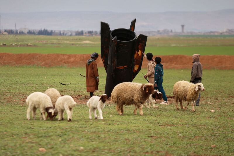 Exposing themselves to the danger of unexploded ordnance, shepherd boys inspect an unexploded Iranian projectile that landed in an open field on the outskirts of Qamishli, eastern Syria, Wednesday, March 4, 2026. (AP Photo/Baderkhan Ahmad)