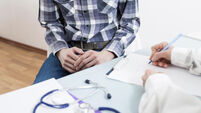 A male patient consults with a doctor about prostate cancer or some other disease.