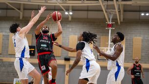 <p>THREE'S A CROWD: Ballincollig’s Latavious Mitchell leaps to take a shot surrounded by Belfast Star players. Pic: Chani Anderson</p>