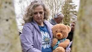<p class="contextmenu internal_Caption">Carmel Cantwell holding a teddy bear bearing the name of her deceased infant brother William during Sunday's vigil at Bessborough, the site of a Cork City mother and baby home. Picture: Chani Anderson</p>