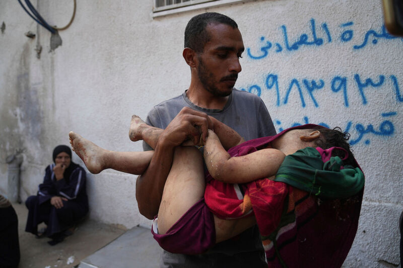 Aug. 22, 2025: Alaa Hassanein carrying the remains of his four-year-old niece, Sara Hassanein, at Al-Shifa Hospital in Gaza City. She was killed in an Israeli military strike on a school used as a shelter. Picture: Abdel Kareem Hana/AP