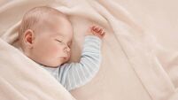 Baby sleeping covered with soft white blanket