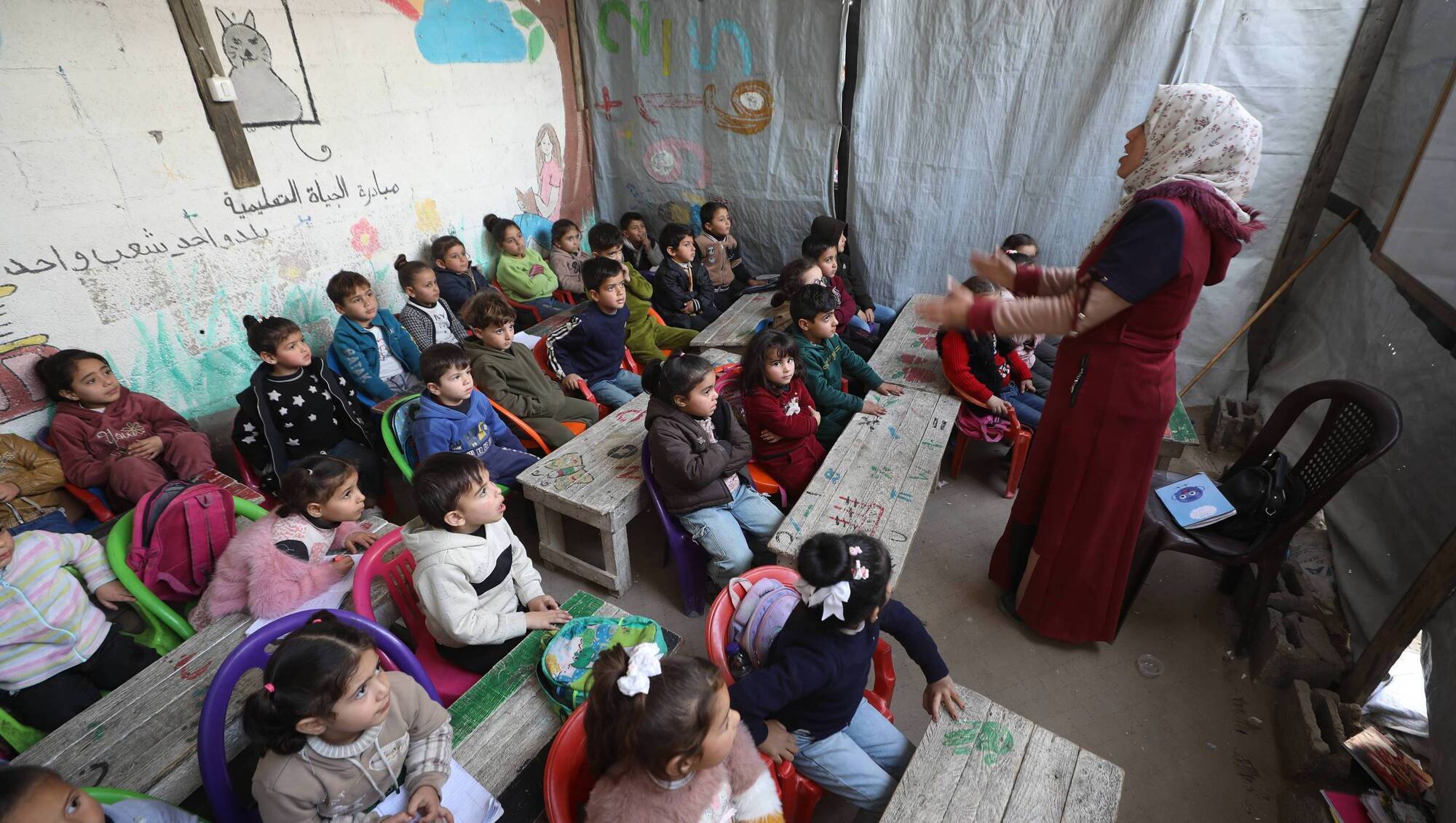 Displaced Palestinian children receive lessons inside a tent in a camp for displaced people in the Yarmouk area of Gaza City. Palestinians are, tragically, once again paying a heavy price for the war in Iran. Picture: Omar Ashtawy