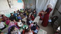 Displaced Palestinian children receive lessons inside a tent in a camp for displaced people in the Yarmouk area of ??Gaza City.